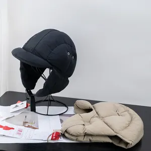 Detail of quilted winter trapper hats with ear flaps and adjustable buckles in black and beige