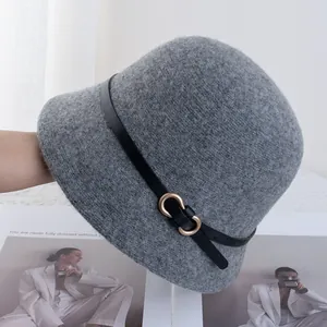 Dettaglio cappello cloche in lana grigia con cinturino in pelle nera e fibbia in metallo oro