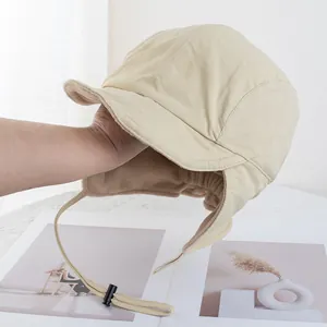 Λεπτομέρεια από μπεζ ποδηλατικό σκούφο με fleece επένδυση, προστατευτικά αυτιών και λουράκι