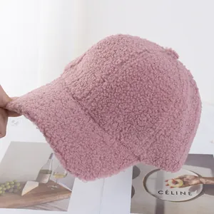 Close-up of soft pink fuzzy teddy fleece fabric texture on a warm winter baseball cap