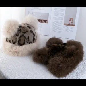 Plush leopard print winter hats with fluffy pom-poms in beige and brown faux fur