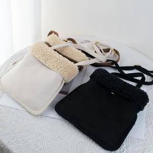 Brown faux suede crossbody bag with fleece trim in cream and black colors
