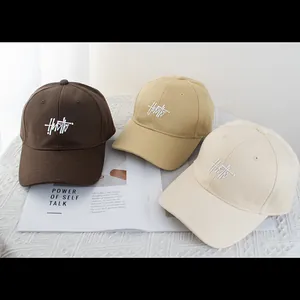 Minimalist cotton baseball caps in brown, khaki, and cream colors with letter embroidery