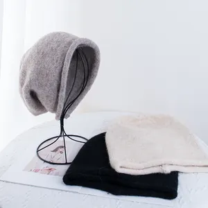 Dettaglio della trama a maglia di berretti oversize grigi, neri e beige per l'inverno