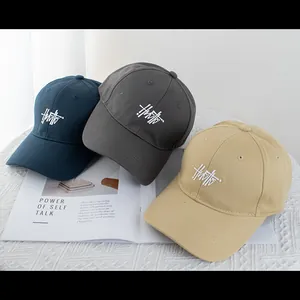 Detailed arrangement of navy, gray, and khaki cotton baseball caps with art embroidery