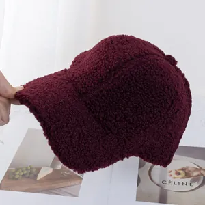 Close-up of burgundy lamb wool baseball cap with thick textured fleece and curved brim