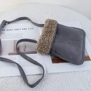 Close-up of gray suede crossbody phone bag with brown faux shearling trim details
