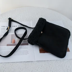 Close-up of black suede crossbody bag with fluffy faux shearling trim and gold button