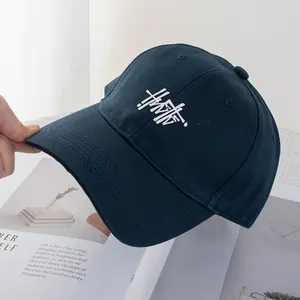 Detail of navy blue cotton baseball cap with white 3D embroidery and reinforced stitching
