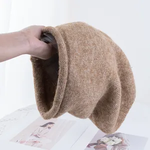 Dettaglio del berretto in maglia marrone che mostra la trama morbida e calda in peluche