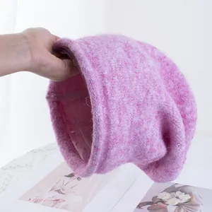 Dettaglio di berretto in maglia peluche color malva con risvolto largo e trama morbida