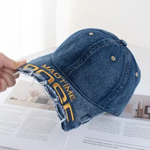 Gros plan sur casquette en jean vieilli avec broderies MADTIME jaunes de style rétro