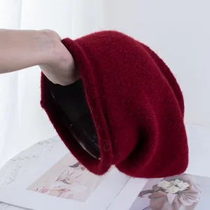 Dettaglio del berretto in maglia bordeaux con trama spessa e fodera termica nera interna