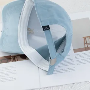Light blue cotton baseball cap with embroidered astronaut and adjustable metal buckle