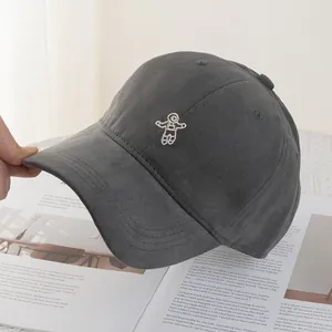 Detail shot of white astronaut embroidery on charcoal grey cotton canvas baseball cap