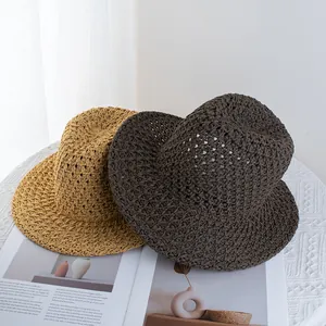 Macro detail of hollow-out woven straw Panama hats in brown and yellow colors
