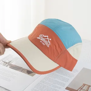 Detail of color-block camp cap with mountain embroidery and quick-dry fabric texture
