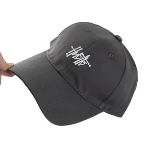 Charcoal grey baseball cap with white graffiti logo and wide brim for casual style