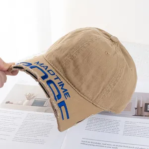 Détail de la casquette en coton kaki vieilli avec broderie MADTIME bleue élégante