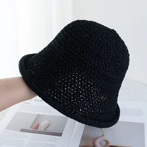 Detailed close-up of a black hollow knit bucket hat with elegant rolled edge and woven texture