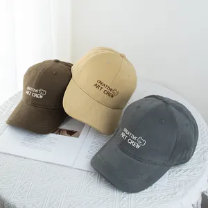Close-up of bear and letter embroidery on cotton baseball caps in brown, khaki, and grey