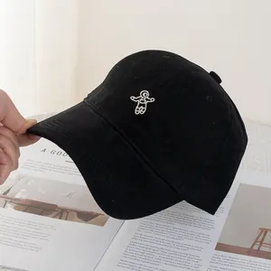 Close-up of embroidered astronaut on a black cotton baseball cap with wide brim