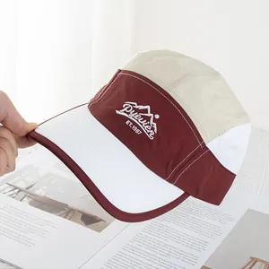Macro detail of color-block camp cap with mountain embroidery and white topstitching
