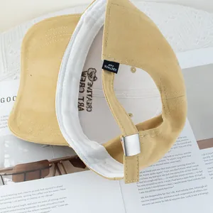 Adjustable mustard yellow canvas baseball cap showing metal buckle and interior logo detail