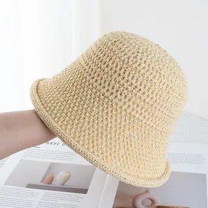 Close-up of the beige crochet bucket hat showing the intricate diamond knit texture