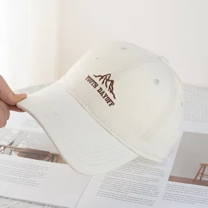 Detail of beige cotton baseball cap featuring mountain embroidery and Youth Dayoff text