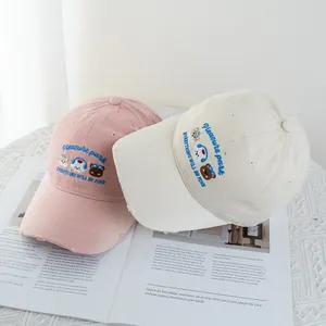 Detail of cute animal embroidery and distressed brim on pink and beige baseball caps