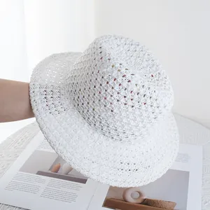 Detailed view of the hollow crochet weave pattern on a white summer straw sun hat