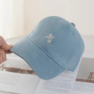 Detailed view of light blue baseball cap featuring a white astronaut embroidery