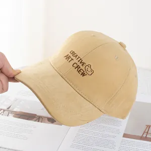 Detail of embroidered cartoon bear and text on beige cotton baseball cap for women