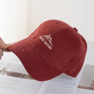 Detail of burgundy baseball cap featuring white Youth Dayoff embroidery and cotton texture