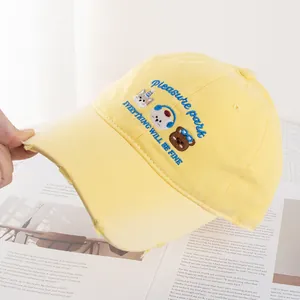 Close-up of cute animal embroidery and distressed brim on a yellow baseball cap