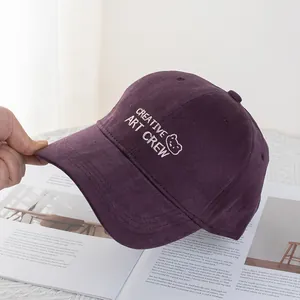 Detail of burgundy cotton baseball cap with white bear embroidery and creative art crew text