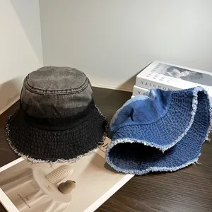 Détail montrant les bords effilochés et coutures blanches sur chapeaux bobs en denim
