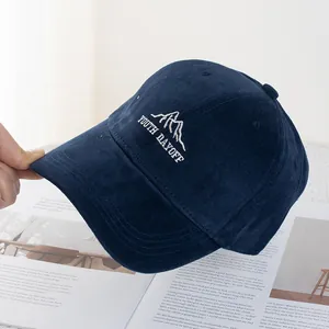 Detail of navy blue corduroy fabric with white mountain and youth embroidery on the cap