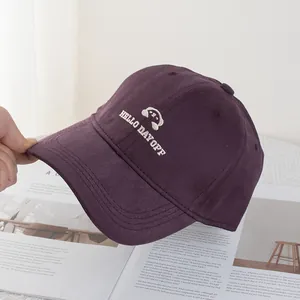 Dettaglio del ricamo bianco e del tessuto in twill di cotone su un cappello viola