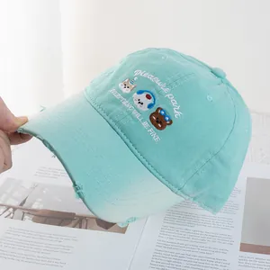 Detail of cute animal embroidery and distressed brim on mint green baseball cap
