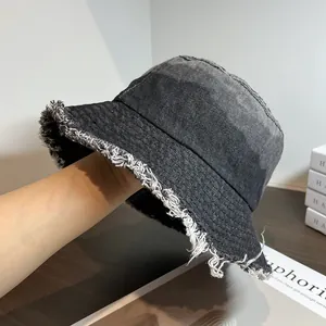 Vue macro détaillée montrant la texture des bords effilochés du chapeau bob en jean gris