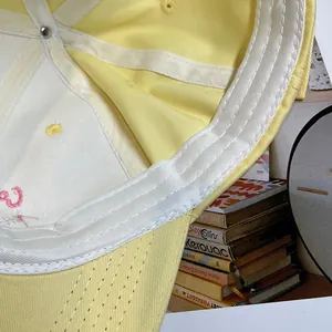 Dettaglio ravvicinato delle cuciture del cappellino giallo e della fascia antisudore