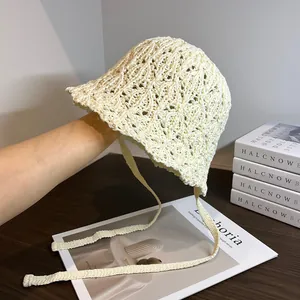 Dettaglio della trama traforata all'uncinetto e dei lacci del cappello da pescatore