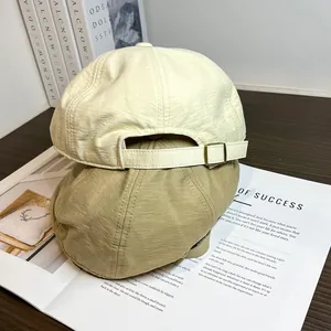 Vue détaillée de l'arrière de casquettes vintage avec boucles métalliques en beige et kaki
