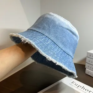 Détail d'un chapeau bob en jean bleu clair avec bords effilochés et texture délavée rétro