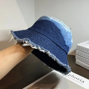 Gros plan des bords effilochés et de la texture du bob en denim bleu dégradé vintage