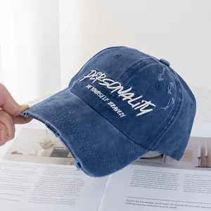 Detail einer gewaschenen blauen Jeans-Baseballkappe mit Stickerei und Distressed-Effekt