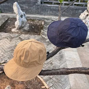 Lightweight nylon quick-dry sun hats in khaki and navy blue on a tree branch