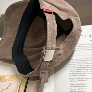 Adjustable brown cotton baseball cap with matte silver buckle and red label detail